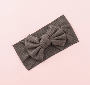 Detailed texture of brown ribbed knit baby headband with a decorative large bow