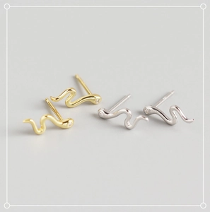 Macro view of S925 sterling silver snake earrings with tiny crystals in gold and silver