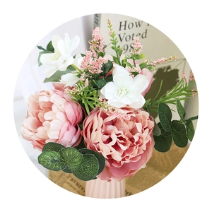 Bridal pink peony bouquet with eucalyptus leaves in a striped ceramic vase