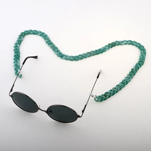 Close-up of green marble acrylic chain attached to black round metal frame sunglasses