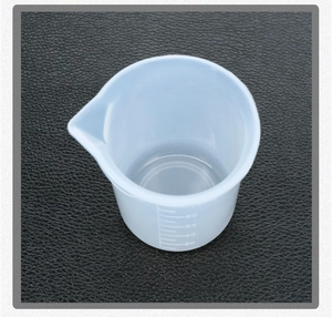 Detail showing 100ml silicone measuring cup with clear scale marks and pouring spout