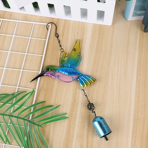 Close-up of a colorful metal and glass hummingbird wind chime with a blue metal bell
