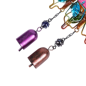 Detail of colorful butterfly wind chime featuring purple and bronze bells with glass beads