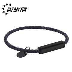 Close-up of braided fiber bracelet featuring a matte black metal clasp and round pendant