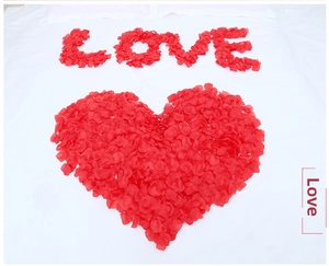 Red silk rose petals forming a heart and Love shape for romantic wedding room decoration