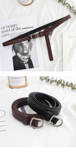 Detailed view of slim black and brown leather belts with matte silver D-ring buckles
