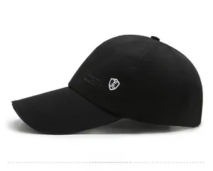 Detail of black baseball cap featuring white shield embroidery and genuine sports logo