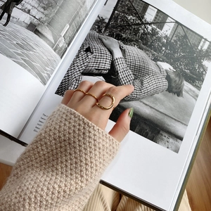 Chic gold-plated geometric ring set shown on a hand against a fashion magazine backdrop