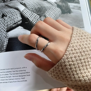 Close-up of minimalist 925 silver double-line open ring on model hand with cozy sweater