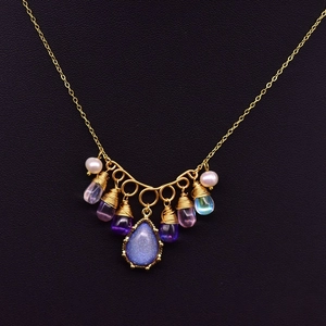 Golden pearl necklace with blue gemstone pendant and multi-color crystal accents