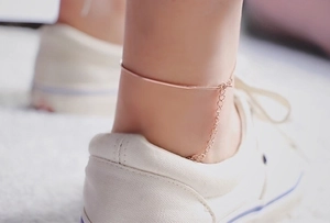 Close-up of rose gold snake chain anklet with extension on woman's ankle