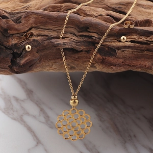 Vue détaillée du collier rond évidé et des boucles d'oreilles boules sur bois naturel