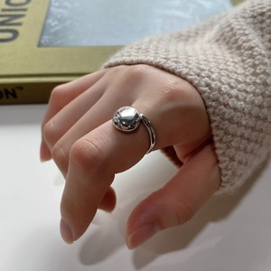Close-up of minimalist silver water drop ring with polished spherical mirror finish