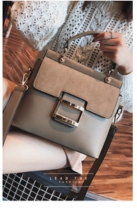 Close-up of khaki square crossbody bag with suede flap and metal buckle on wooden floor