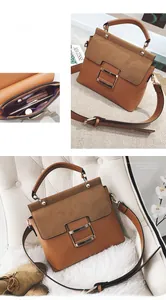Detailed view of brown leather crossbody bag with metal buckle and tiered interior