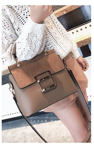 Detail of vintage crossbody bag showing golden metal buckle and matte texture