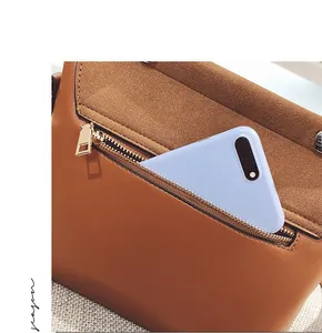 Detailed view of the back zipper pocket on a brown leather crossbody bag with smartphone