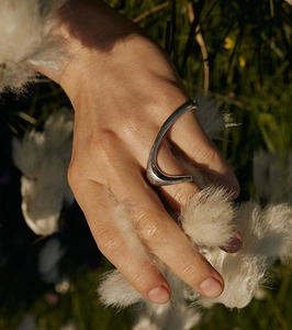 Detail shot of organic curved 925 silver ring worn on index finger in natural light