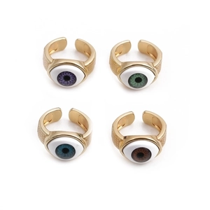Detail of gold-plated open rings with micro-set zircon evil eye and seashell design