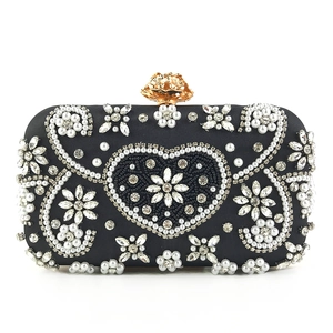 Detailed front view of luxury black evening bag with pearl floral embroidery and crystals