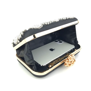 Macro view of handmade pearl and rhinestone evening bag showing interior phone capacity