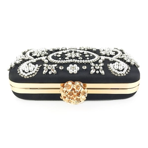 Detail of evening clutch featuring intricate pearl embroidery and crystal floral patterns