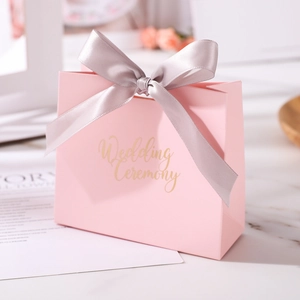 Detailed macro view of a pink trapezoid wedding candy gift box with a grey satin ribbon