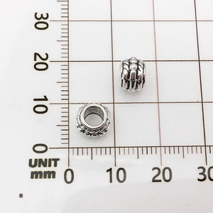 Macro shot of silver alloy elephant spacers showing 10mm height on a metric measurement board