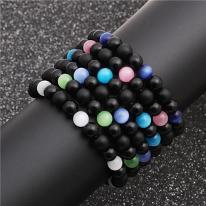 Macro shot of matte black beads and colorful cat eye stones on a bracelet display