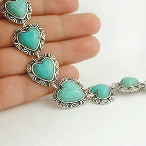 Macro shot of heart-shaped turquoise stone with vintage silver engraved border detail