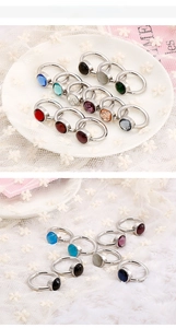 Detailed view of assorted minimalist rings with colorful cat eye stones on lace background