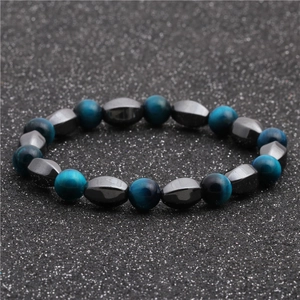 Dettaglio delle perle occhio di tigre e pietre di ematite su un bracciale di perline