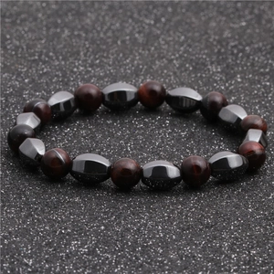Dettaglio delle pietre occhio di tigre lucide e perle di ematite su un bracciale a sfere