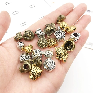 Dettaglio di perline in metallo a testa di animale per bracciali fai-da-te in oro e argento