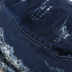Close-up of vintage washed denim bucket hat with distressed holes and frayed edges