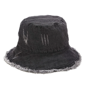 Detail view of the distressed denim bucket hat with frayed edges and ripped holes