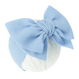 Close-up of light blue waffle knit baby headband with a large decorative bow detail