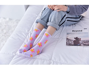 Detailed view of kids purple cotton socks with yellow sunflower smiley face pattern