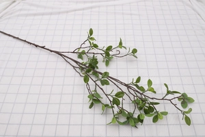 Close-up of realistic faux Milan leaves with green foliage and brown stems for home decor