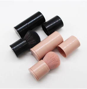 Detail view of retractable makeup brushes in black and nude pink with protective caps