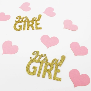 Close-up of golden glitter It's a GIRL letters and pink hearts for baby shower decoration