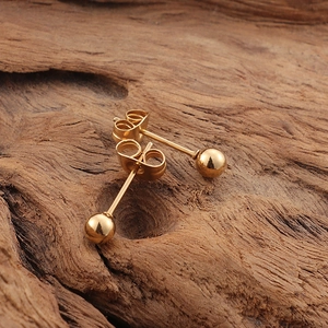 Minimalist 18K gold plated butterfly stud earrings displayed on natural wood background