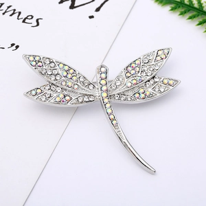 Macro detail of a dragonfly brooch with sparkling crystals and silver wing patterns