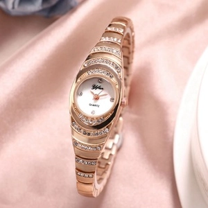 Detail view of a rose gold Yifuo quartz watch with crystal inlay on pink silk background