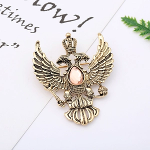 Macro detail of vintage double-headed eagle brooch with pink gemstone and antique gold finish