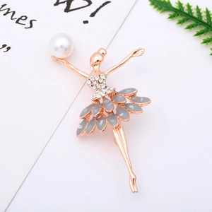 Detailed macro view of a rose gold ballerina brooch with pearl and grey crystals