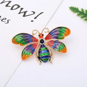 Close-up of a colorful enamel butterfly brooch with a blue stone and gold finish