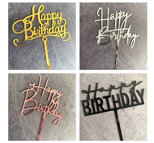 Macro shot of Happy Birthday cake toppers in gold, silver, rose gold and black acrylic