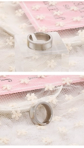 Detail view of silver shell-inlaid open ring on lace and acrylic display stands
