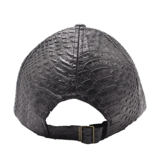 Detail of black faux crocodile skin texture and adjustable metal buckle on baseball cap
